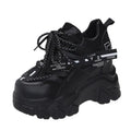 Women's white and black mesh platform sports shoes with cross strap and rubber sole.