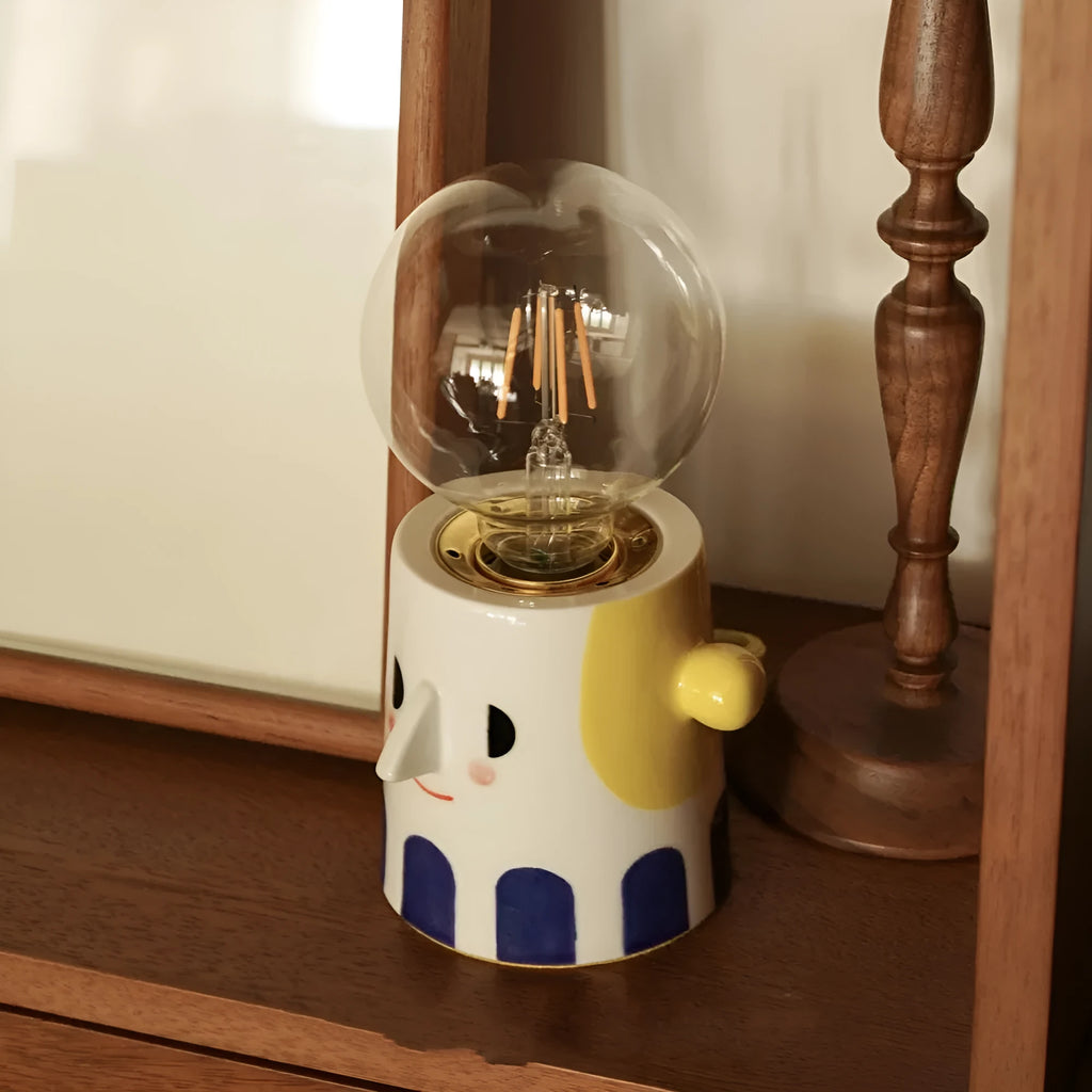 Handmade ceramic lamp with ball headlight design on wooden surface