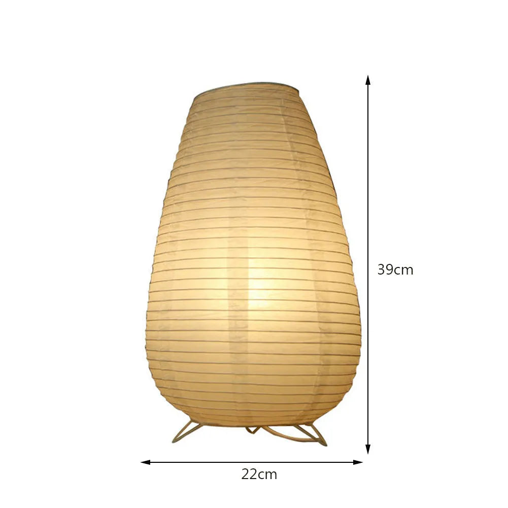 White rice paper plug-in table lamp in circular shape on a wooden bedside table.