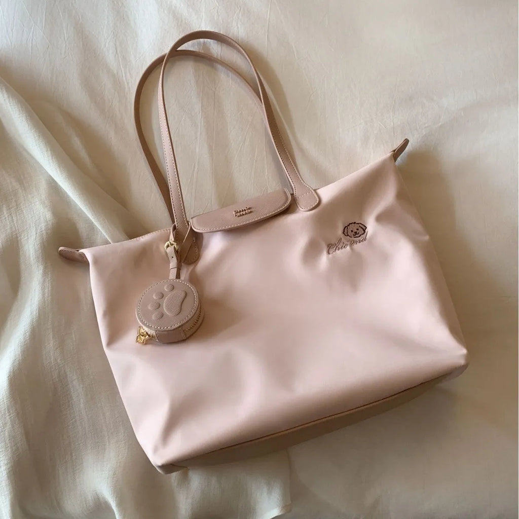 Large pink Oxford cloth tote shoulder bag showing external sandwich pocket and casual design.