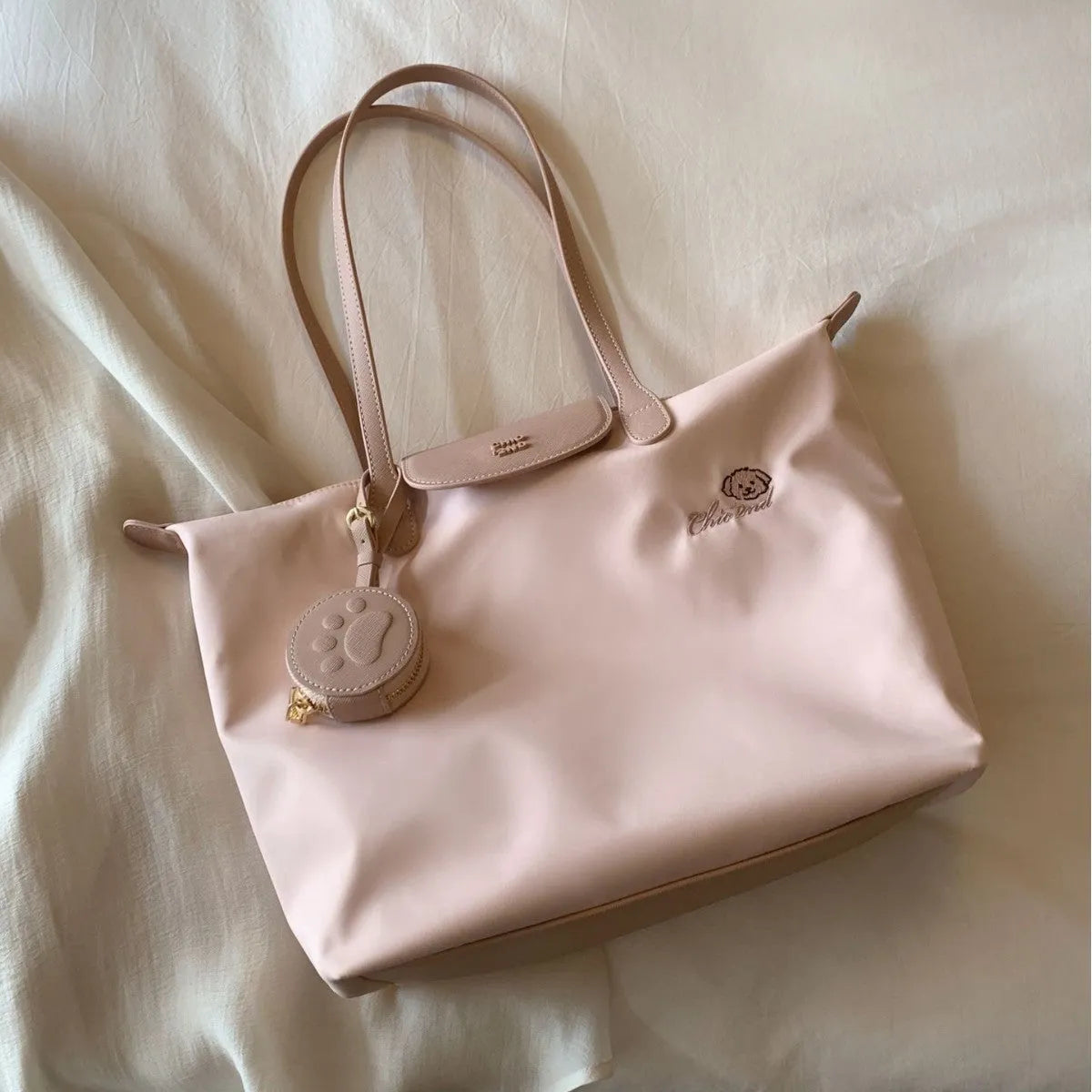 Large pink Oxford cloth tote shoulder bag showing external sandwich pocket and casual design.