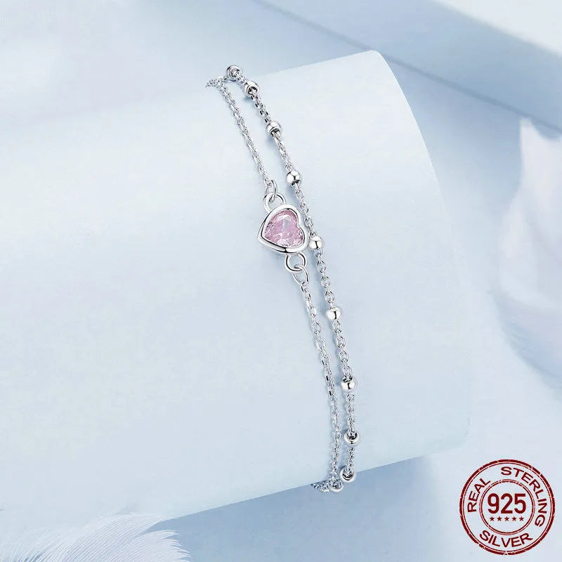 Women's sweet style sterling silver heart bracelet with adjustable chain on white background.