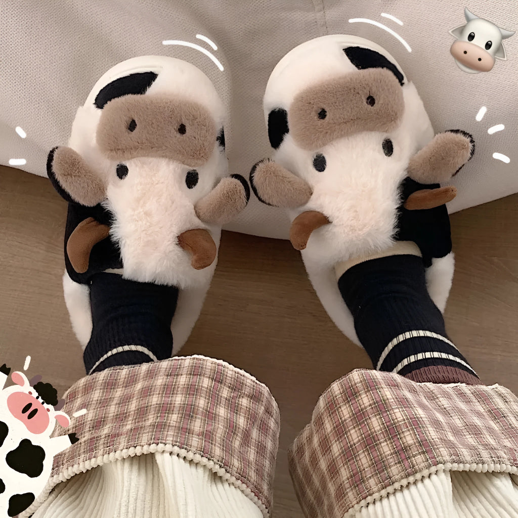 White cartoon cow slippers with plush faux fur and a textured non-slip sole.