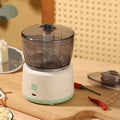 Mini electric meat grinder with transparent cup and stainless steel blades in white or light green