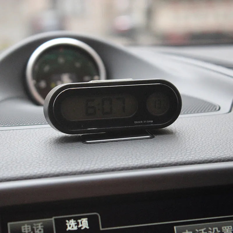Black car electronic clock and thermometer with LED display on an adjustable dashboard bracket.