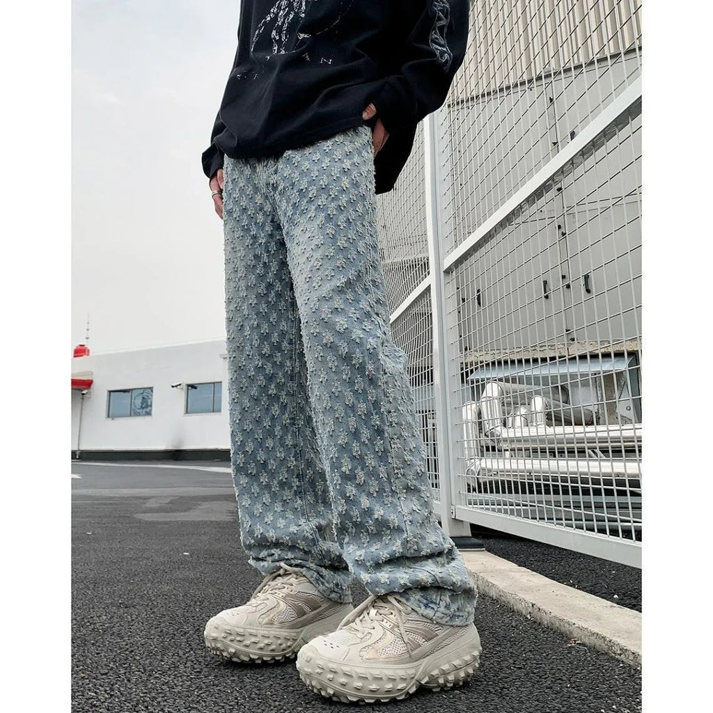 Men's black jacquard full-print denim jeans with button fly, laid flat showing all-over pattern