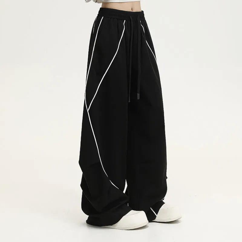 Black and grey striped men's wide-leg pleated sports pants on a hanger.