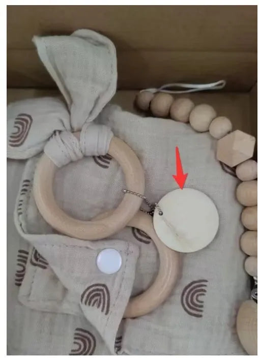 Baby teething toy gift set with bamboo blend gauze blanket, wooden beech bell, teether, brush, and milestone marker.