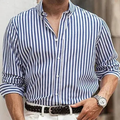 Man wearing a loose-fit khaki striped button-down cardigan-style shirt.