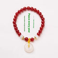 Handmade natural jade and red agate bracelet with silver safety buckle on wooden background