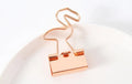 Gold metal decorative paper clip in a bow shape with a long tail design.