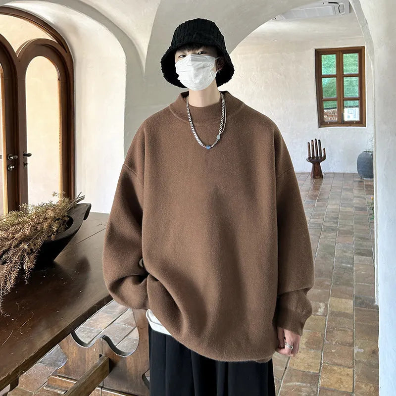 A man's solid colour round neck pullover sweater with long sleeves in a loose, casual fit.