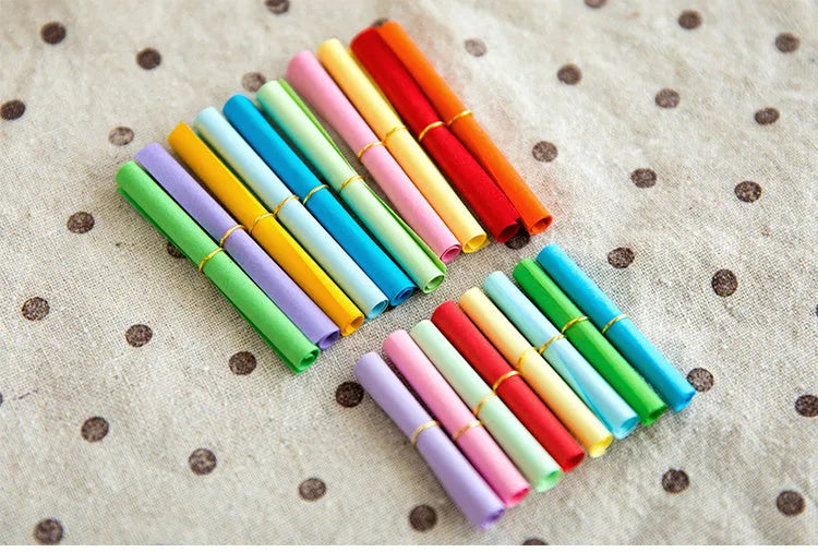 Colourful mini paper scrolls with eyelets in multiple sizes for drift bottle messages