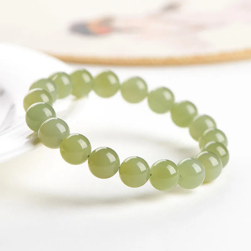 Polished Hetian jade ball bracelet showing ice-clear beads on a wrist, demonstrating deep clear water colour.