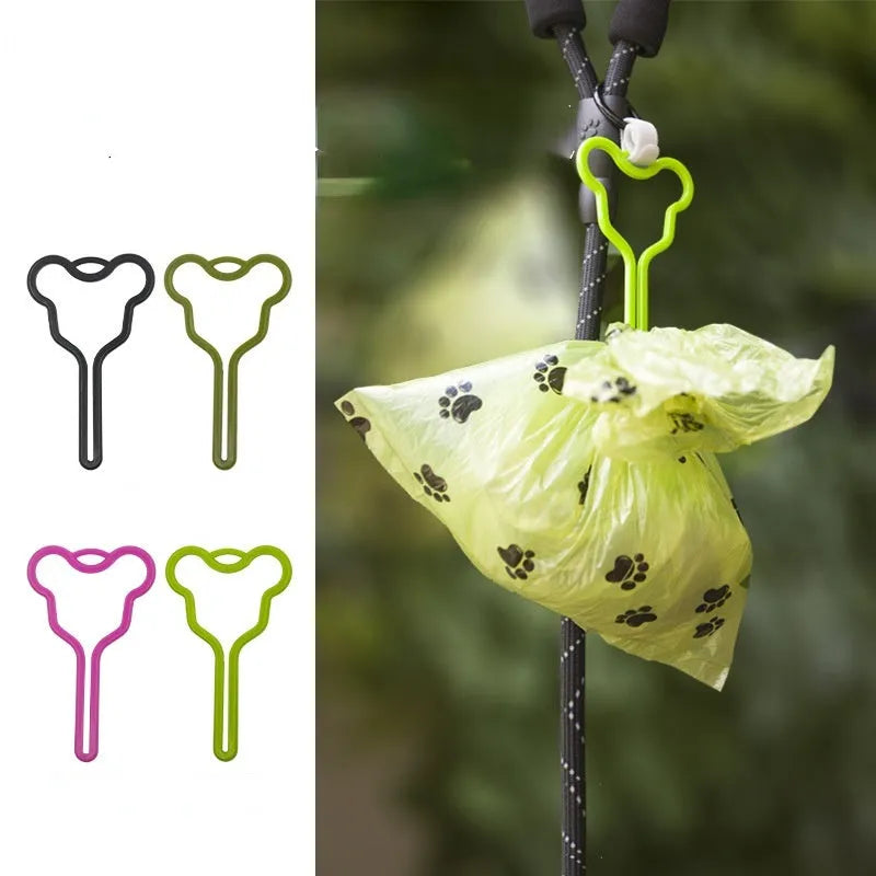 A black dog poop bag holder with a fixed clip and velcro strap, shown attached to a dog leash.