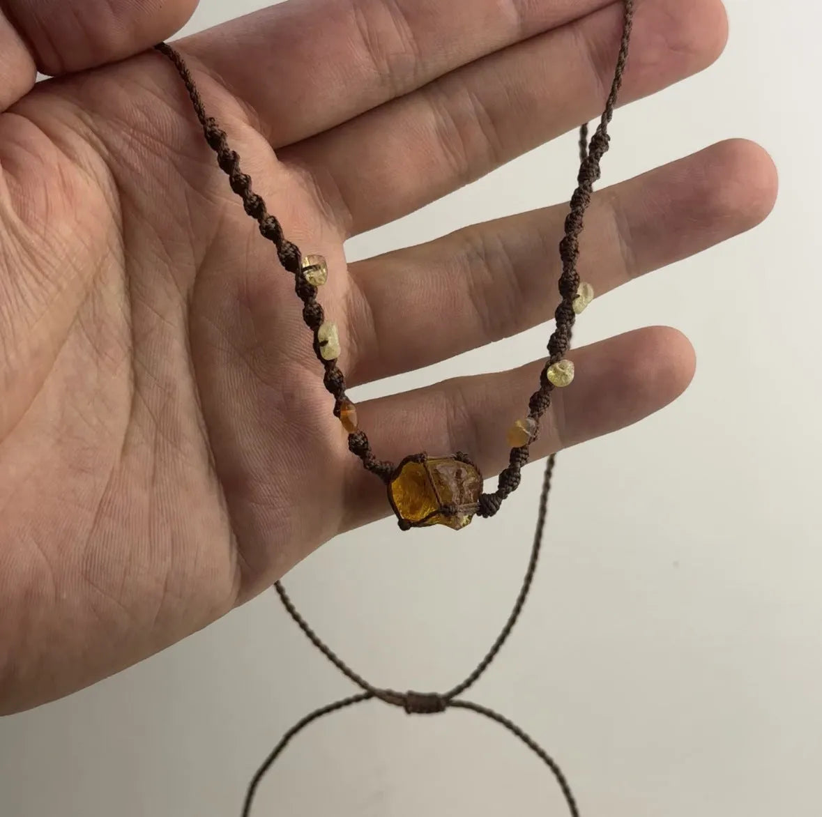 Artificial crystal rough labradorite-style pendant necklace with O-link chain on display