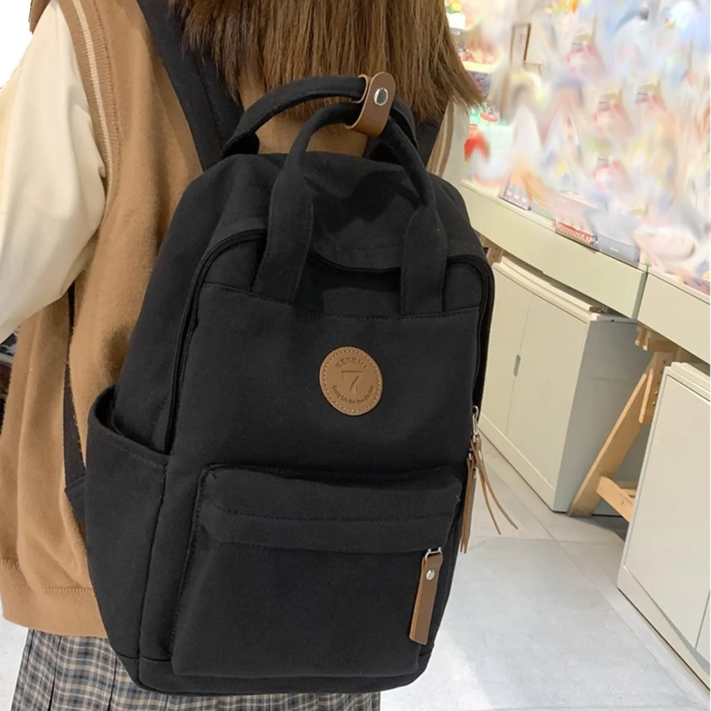 Black retro style Oxford cloth unisex backpack with curved shoulder straps.