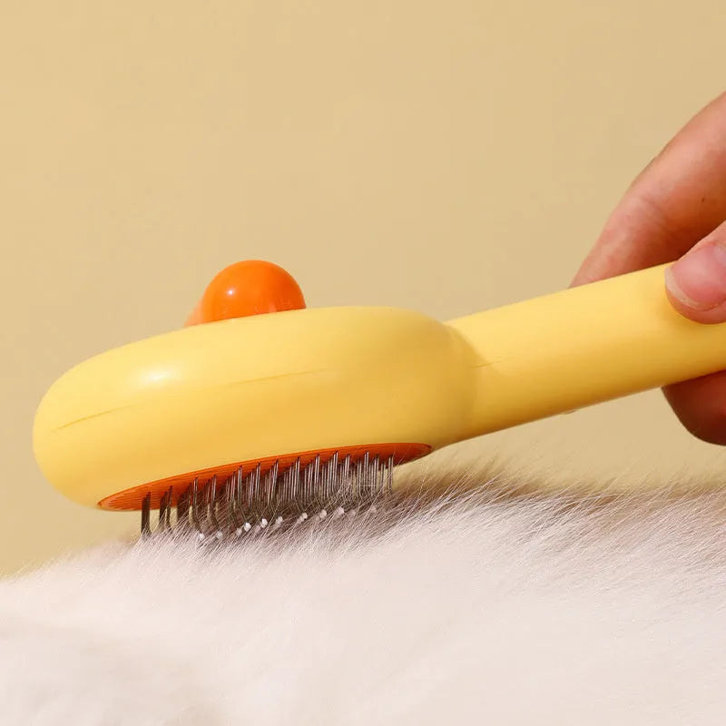 Small yellow duck-shaped pet grooming comb with open needle brush for cats and dogs