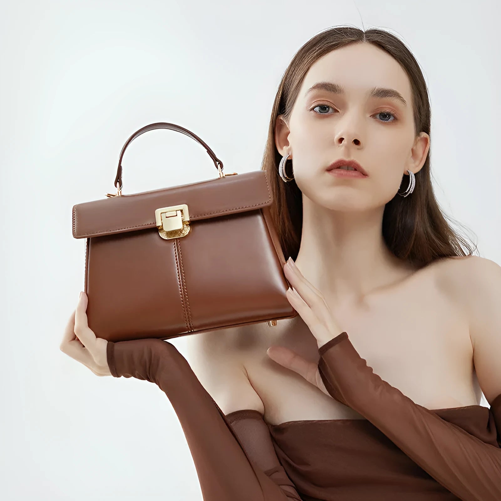 Women's black leather shoulder bag with clasp closure and adjustable strap showing interior organisation