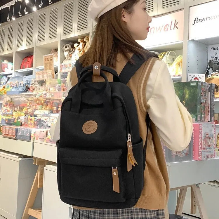 Black retro style Oxford cloth unisex backpack with curved shoulder straps.