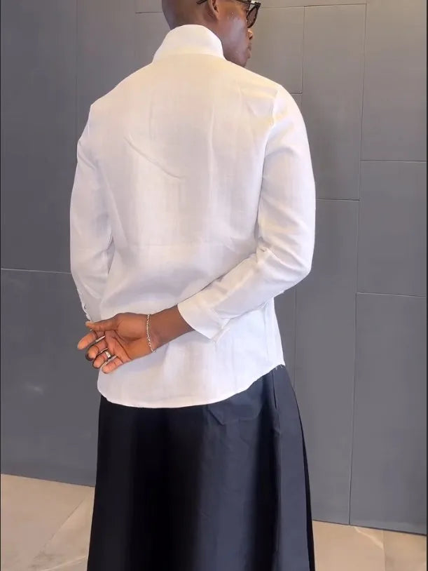 White asymmetric front long sleeve shirt paired with black pleated pants in a women's casual co-ord set.