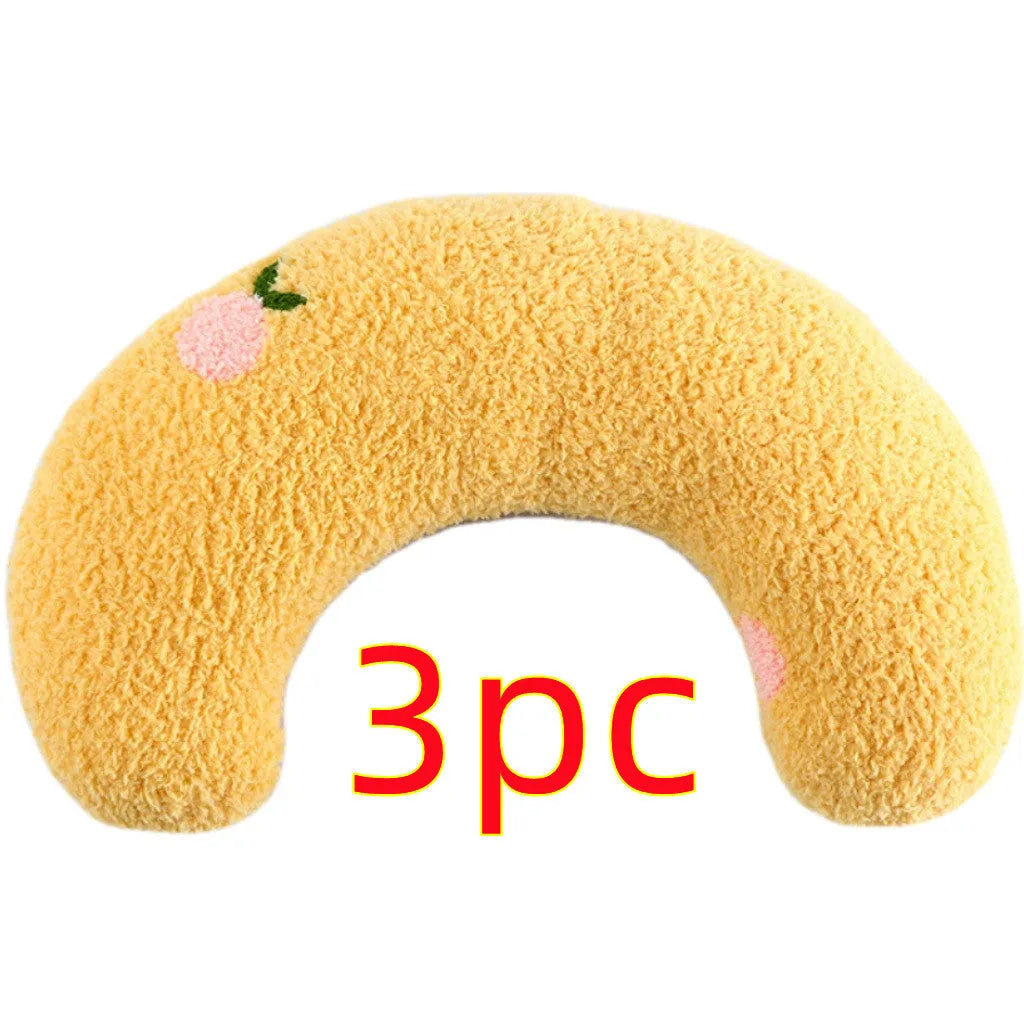 Blue U-shaped plush pet pillow for a small cat or dog on a grey background.