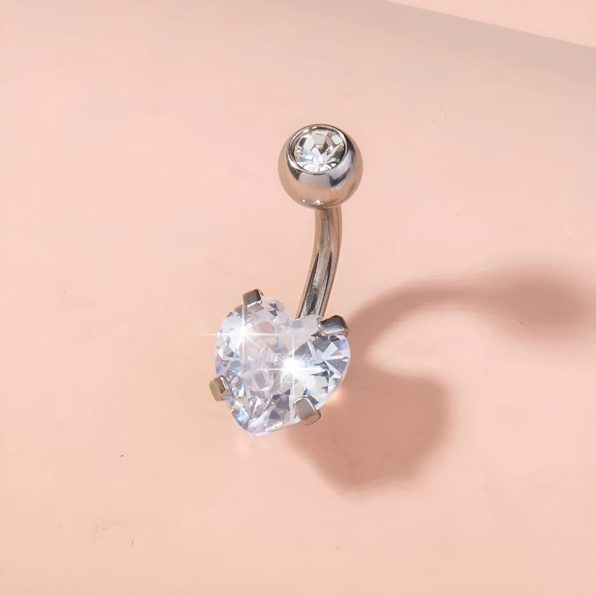Stainless steel heart-shaped zircon navel pin, 0.8 cm wide and 1.8 cm tall, on white background