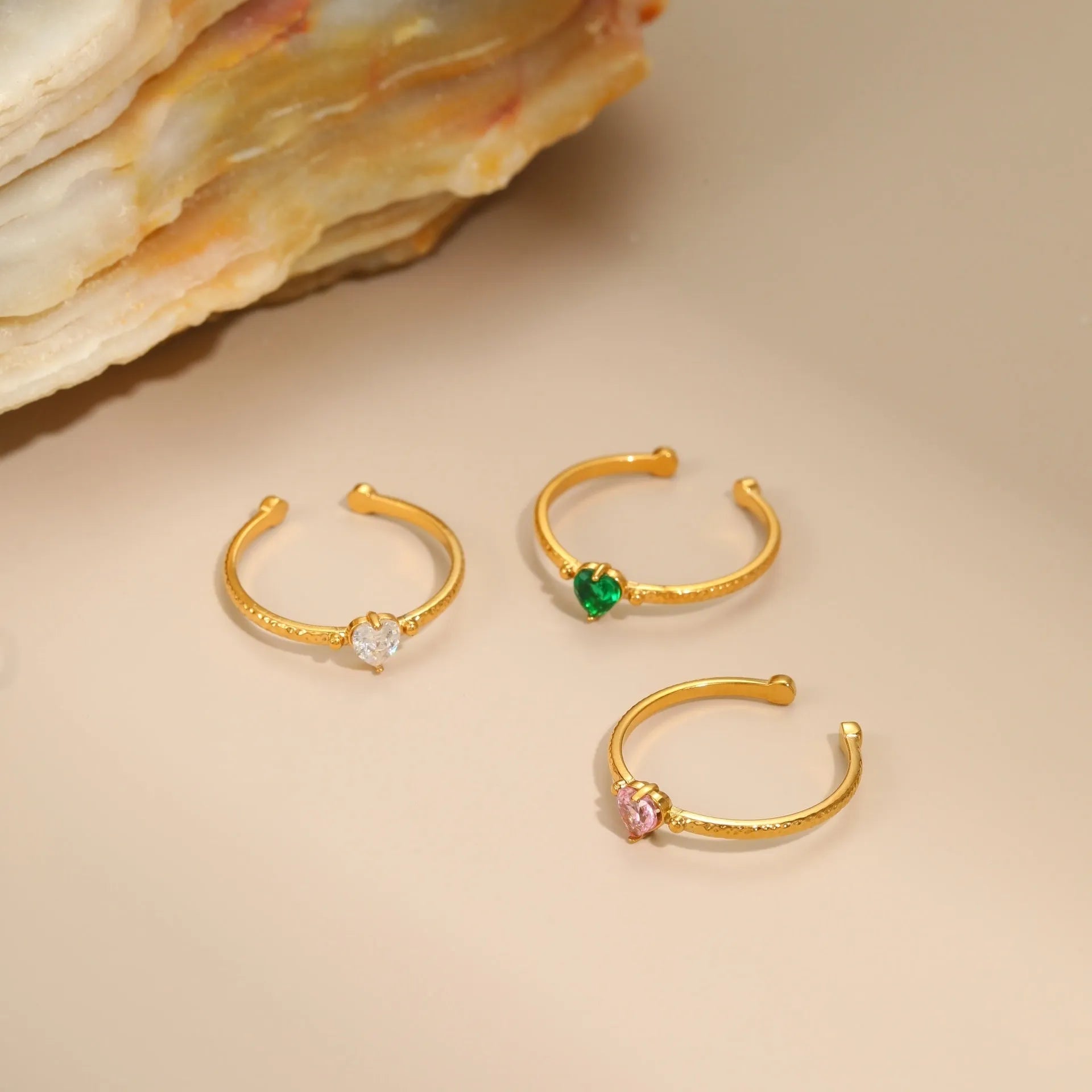 Open-ended stainless steel heart-shaped ring with inlaid zircon stones in green, pink, or white.