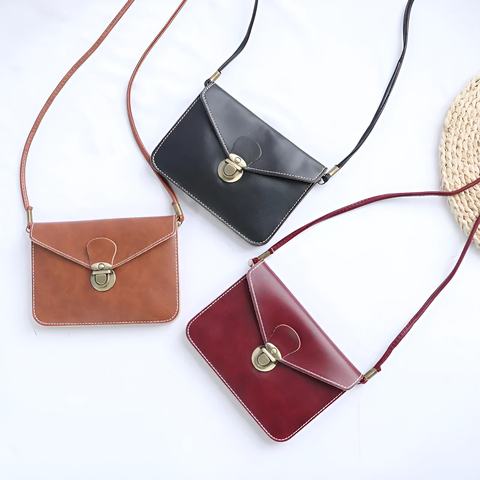 Retro messenger bag in wine red with flap closure and crossbody strap shown alongside black and light brown colour options