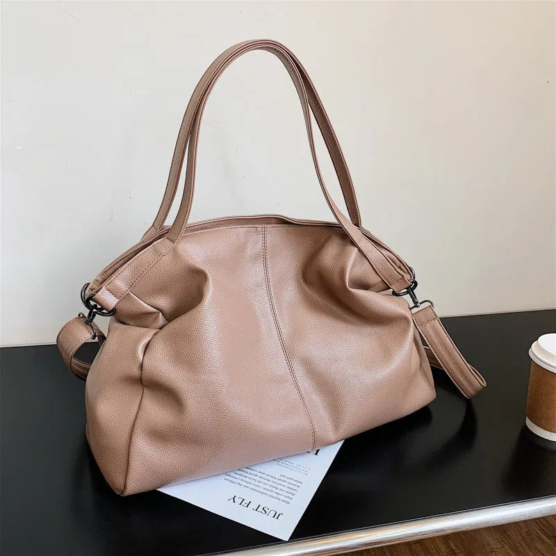Soft black casual messenger tote bag with zip, showing internal phone pocket and adjustable long shoulder strap.