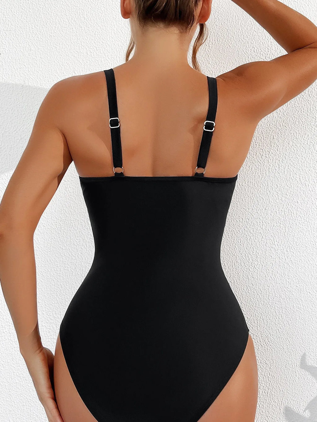 Black women's halter neck one-piece swimsuit with cross-back straps and briefs bottom.