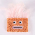 Cat plush toy with big mouth explosion head shape in blue, green, orange, and purple colours