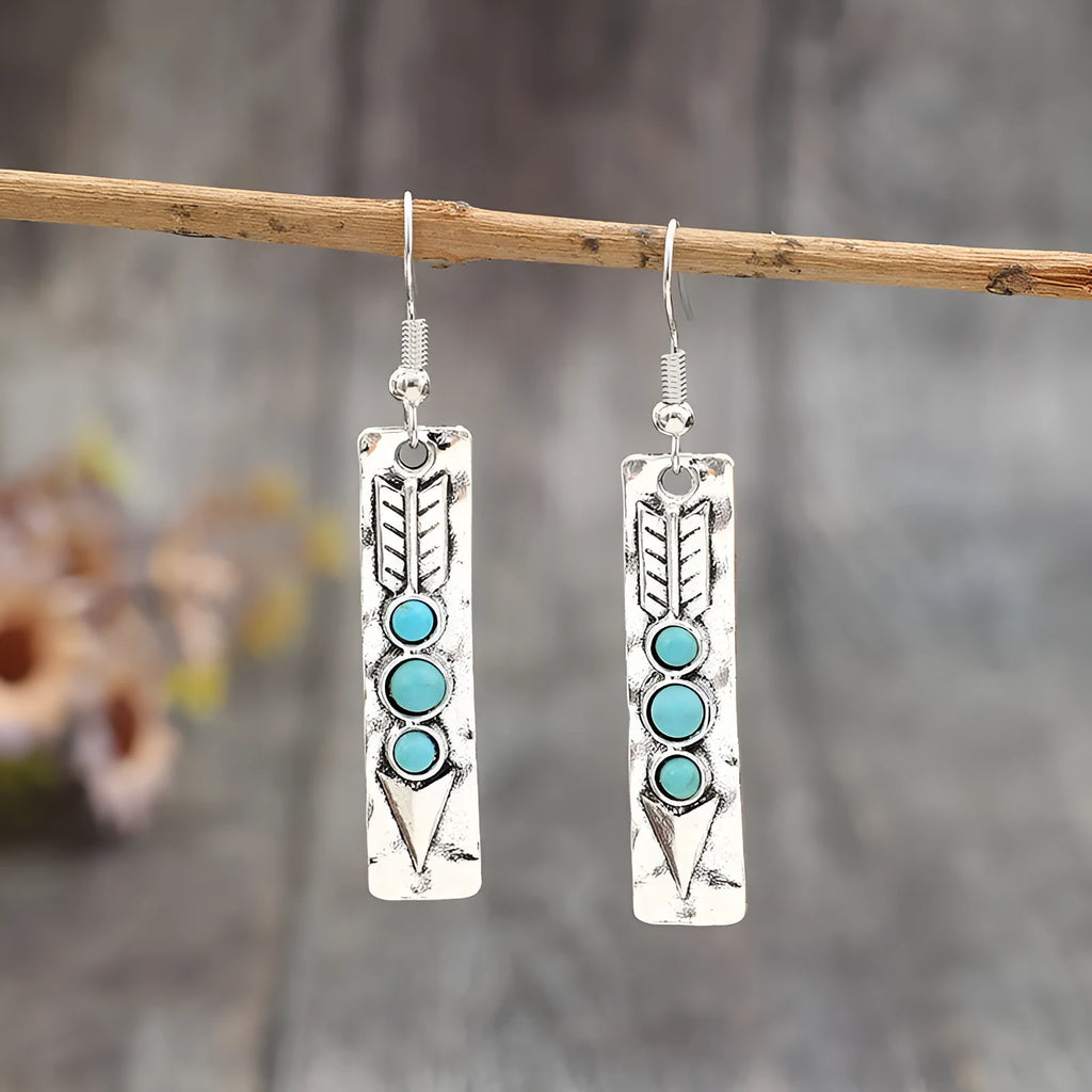 Geometric silver earrings with turquoise inlay pattern and retro styling on long strip design