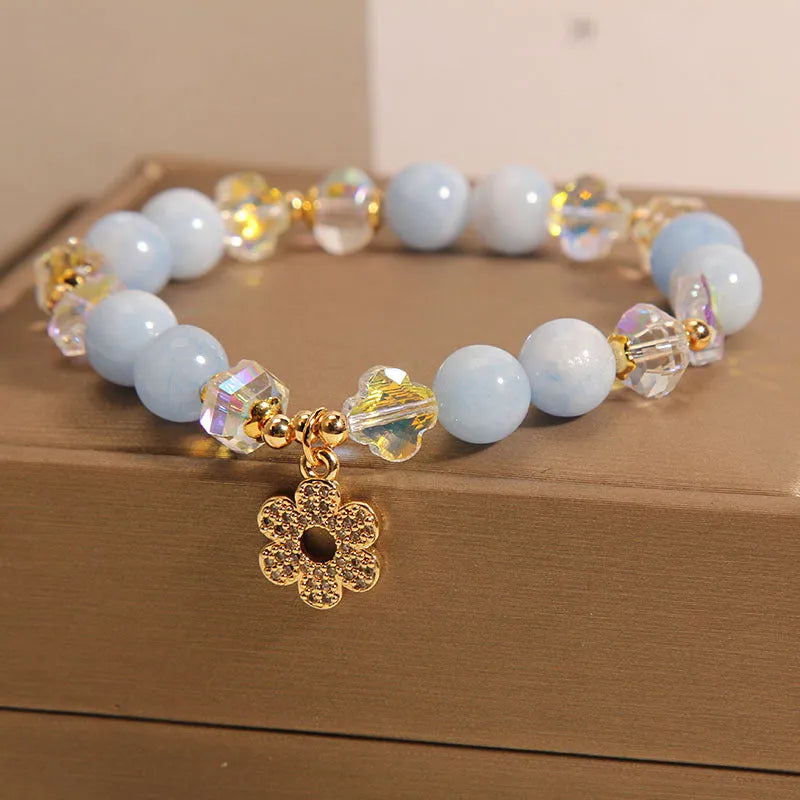 Women's aquamarine crystal bracelet with four-leaf clover charm and pearl accent on a chain