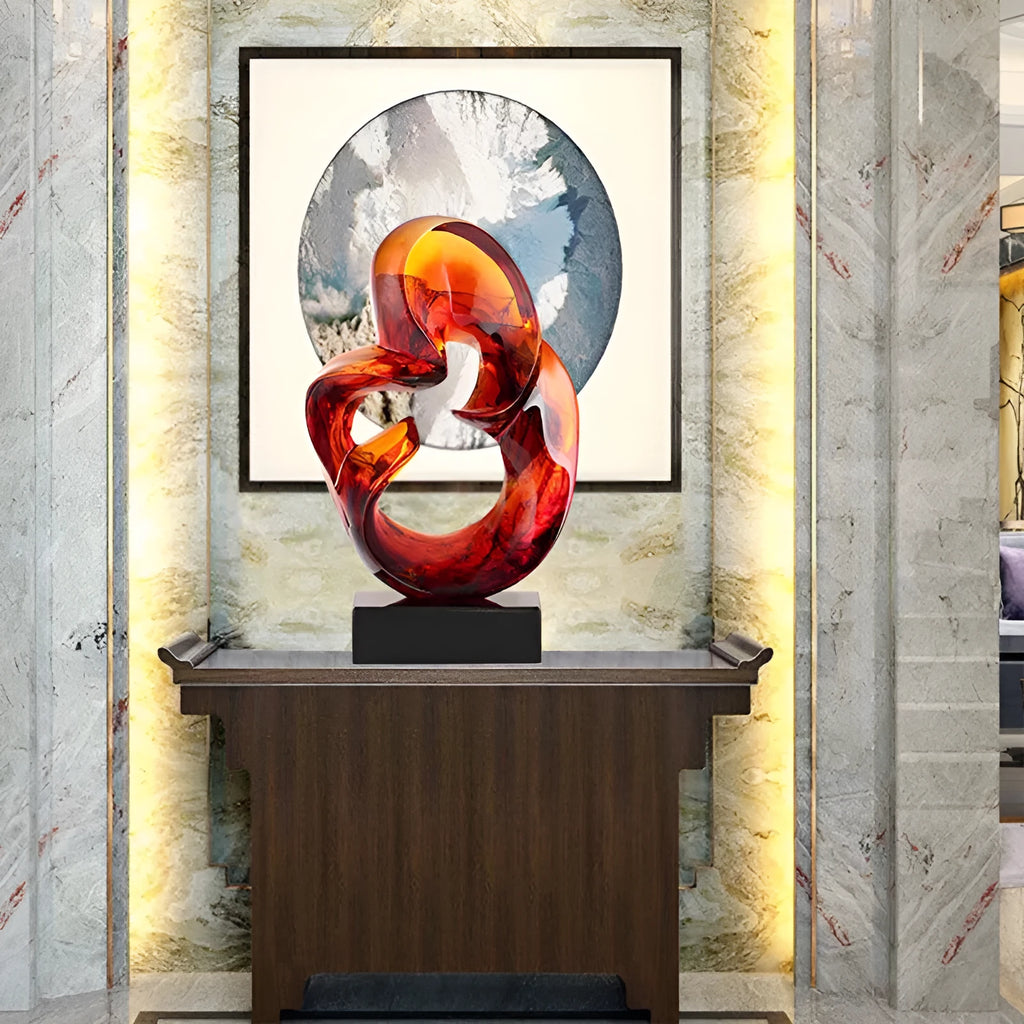 A transparent resin sculpture ornament in a modern style, shown in blue and orange red colour options.