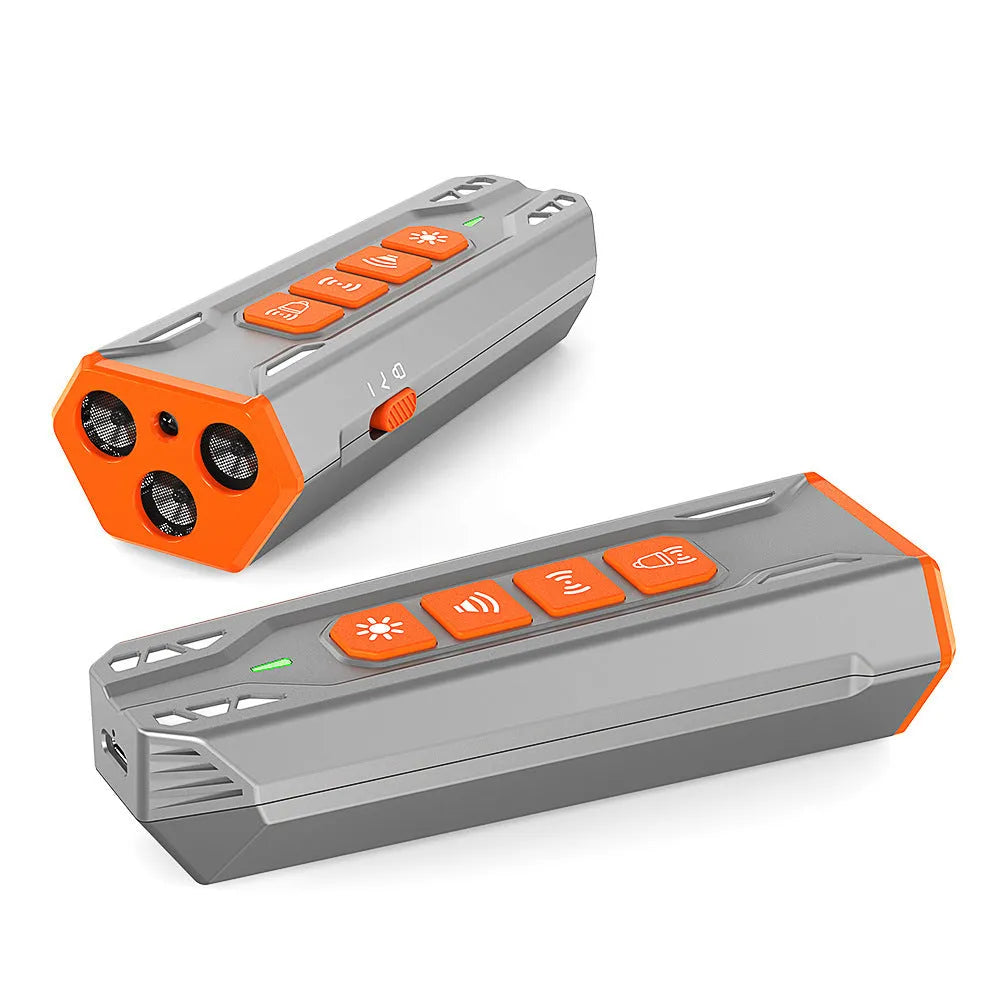 Grey and orange three-head ultrasonic dog trainer with remote control on a table.