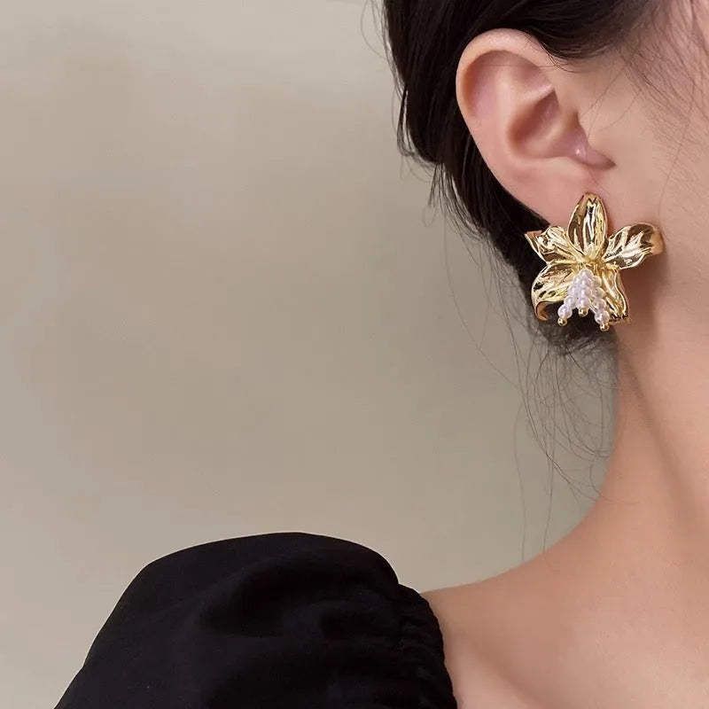Exaggerated gold H1795 pearl flower earrings with Seiko crystal treatment, showing floral design.