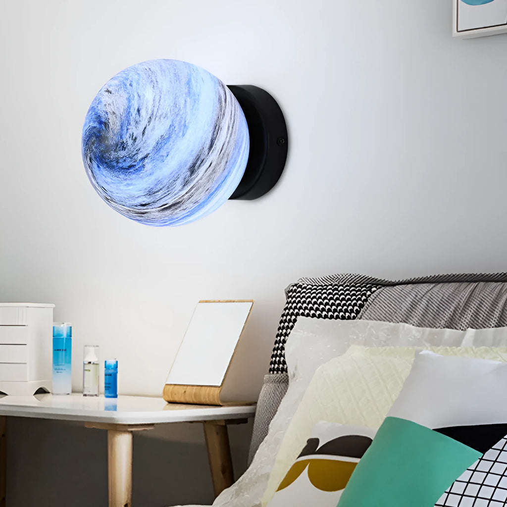 Planet Aisle bedside lamp with painted glass shade in black blue planet colour, on a table
