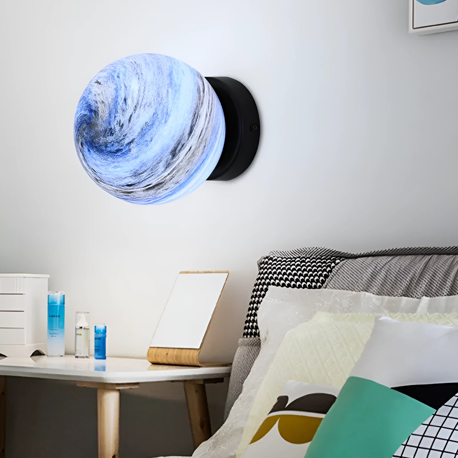 Planet Aisle bedside lamp with painted glass shade in black blue planet colour, on a table
