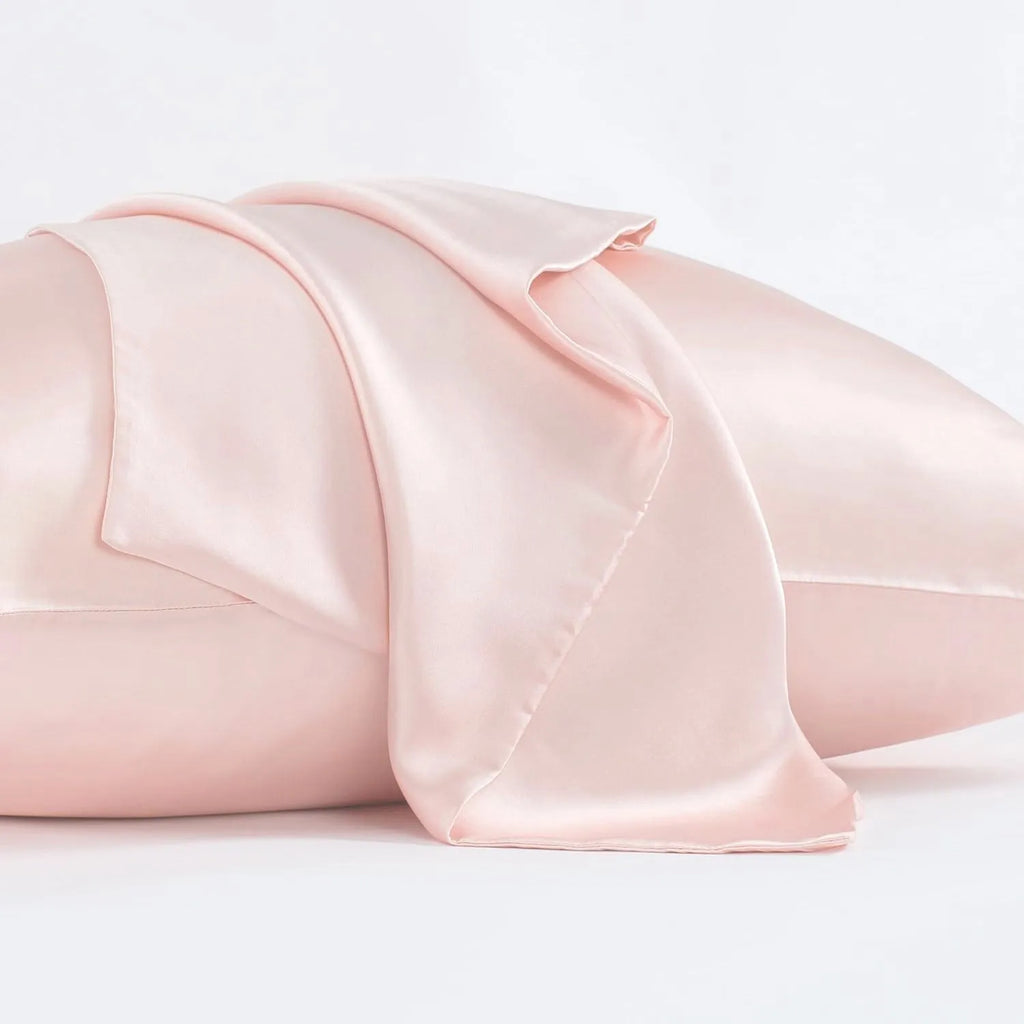 Dark grey silk pillowcase with envelope closure, shown in modern bedding setting.