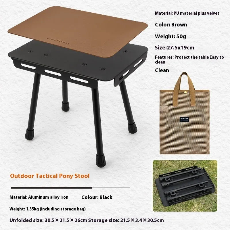 Aluminium folding stool set up as a small table with a beige PU mat cushion, next to its storage bag.