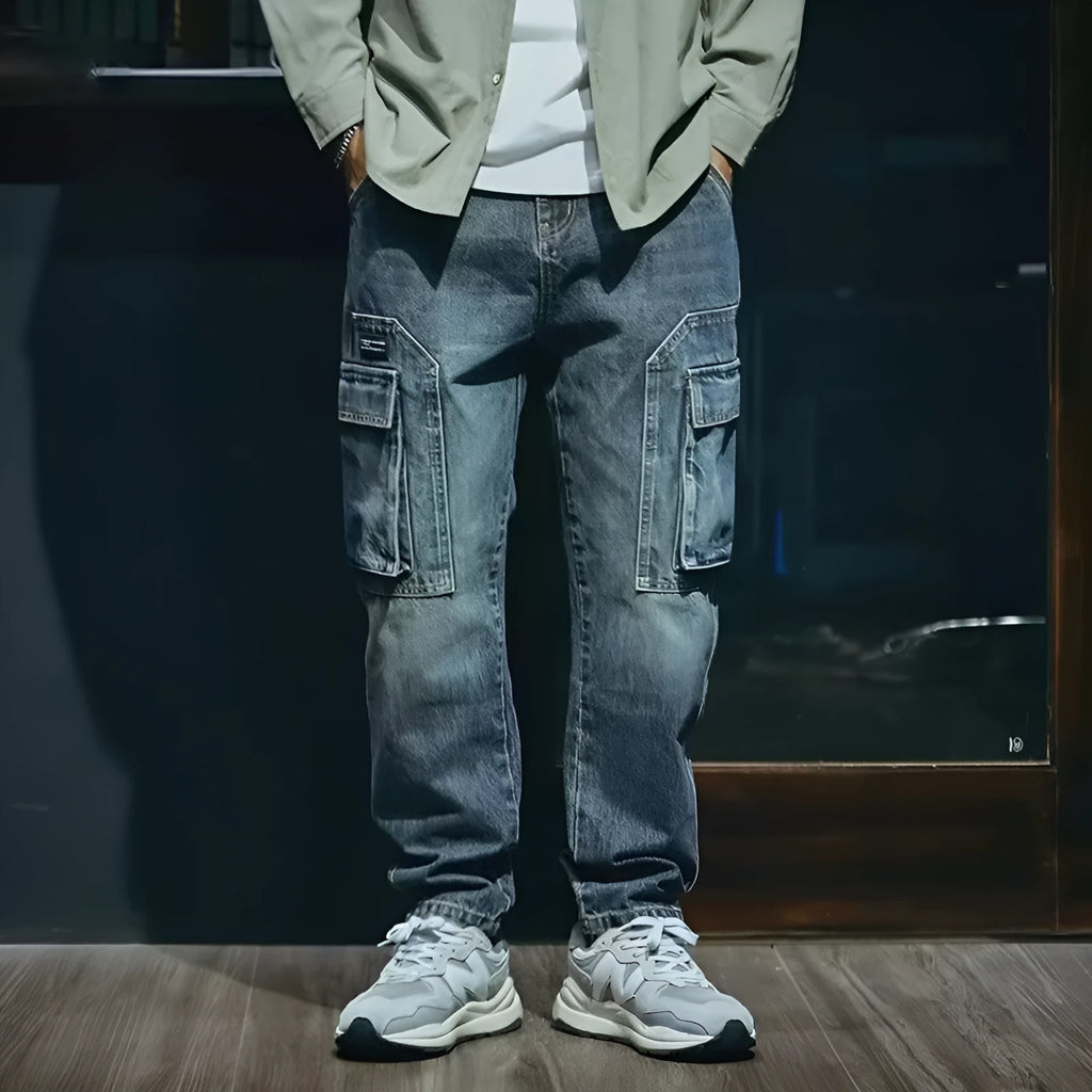 Men's blue loose straight-leg denim trousers with a zip fly placket laid flat.
