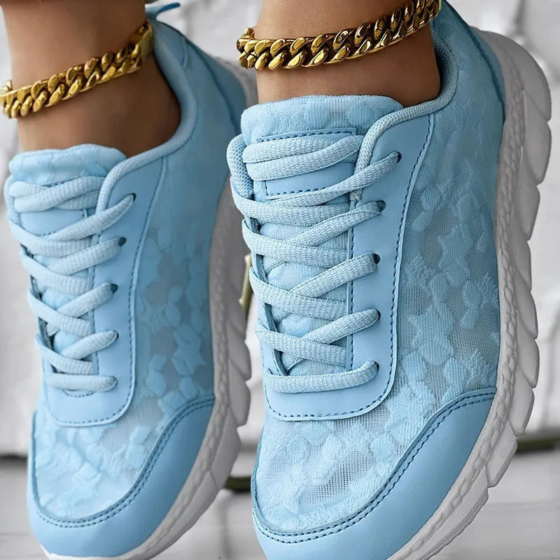 Women's casual canvas sports shoe in four colour options: white, black, blue, and pink, shown with a flat heel.