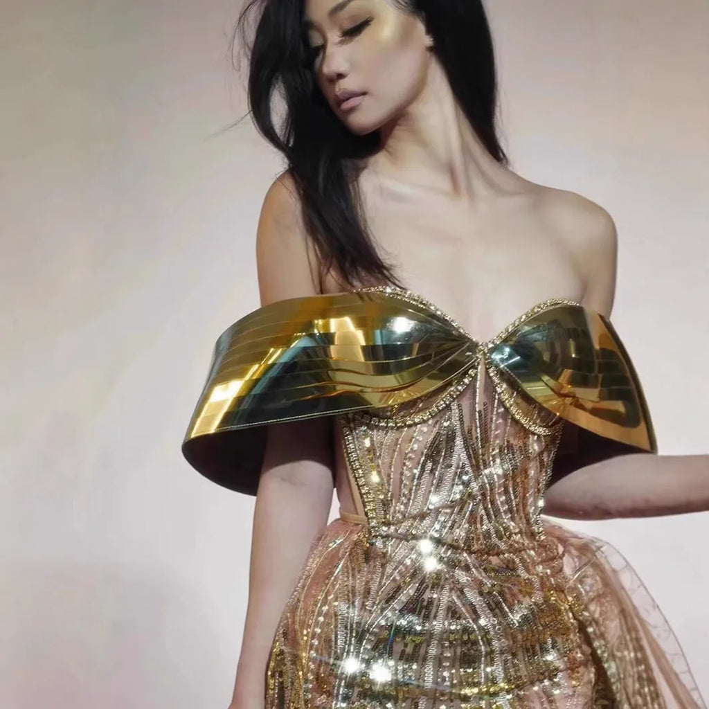 Gold strapless sequin dress with sleeveless tube top and long one-step skirt.