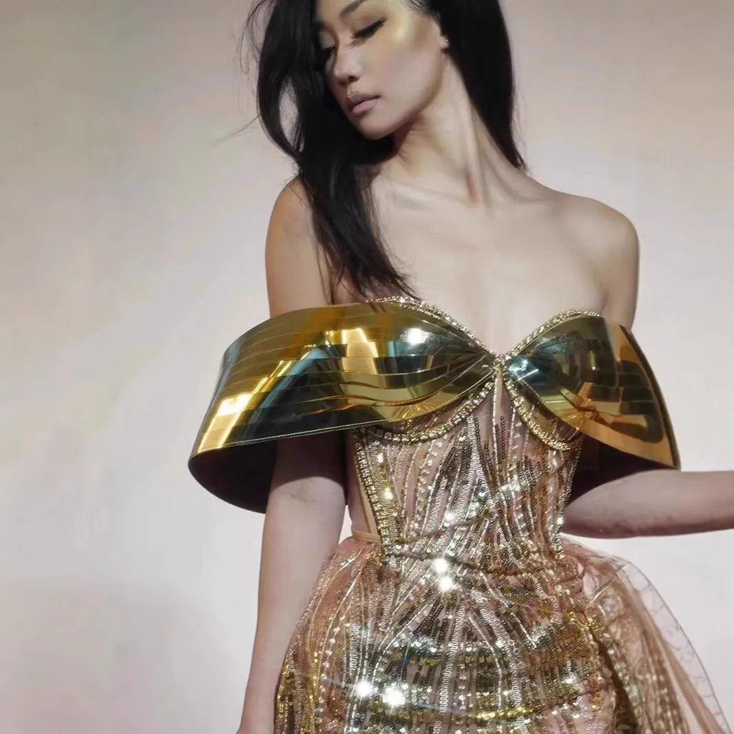 Gold strapless sequin dress with sleeveless tube top and long one-step skirt.