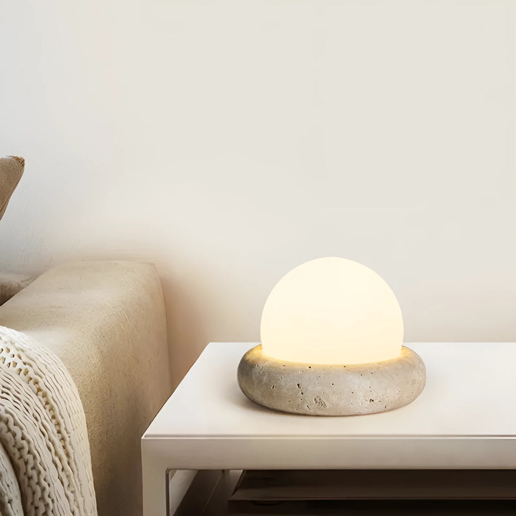 Cream coloured bedside night lamp with remote control on wooden table