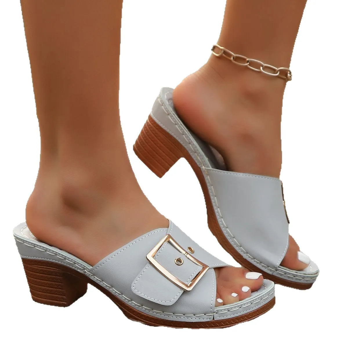 Women's black chunky heel slippers with a round toe and metal buckle detail on a light background.