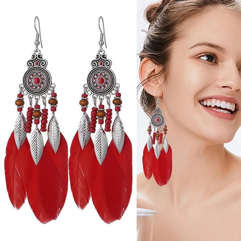 Bohemian style feather drop earrings with round oil craft design in alloy material showing leaf pattern detail