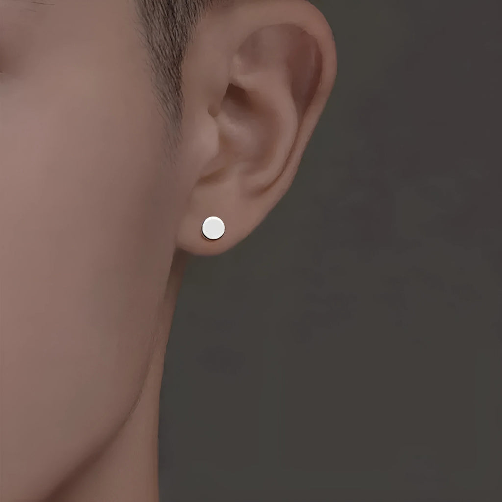 A pair of flat, round sterling silver S999 bone stud earrings on a plain background, showing silver and black colour options.