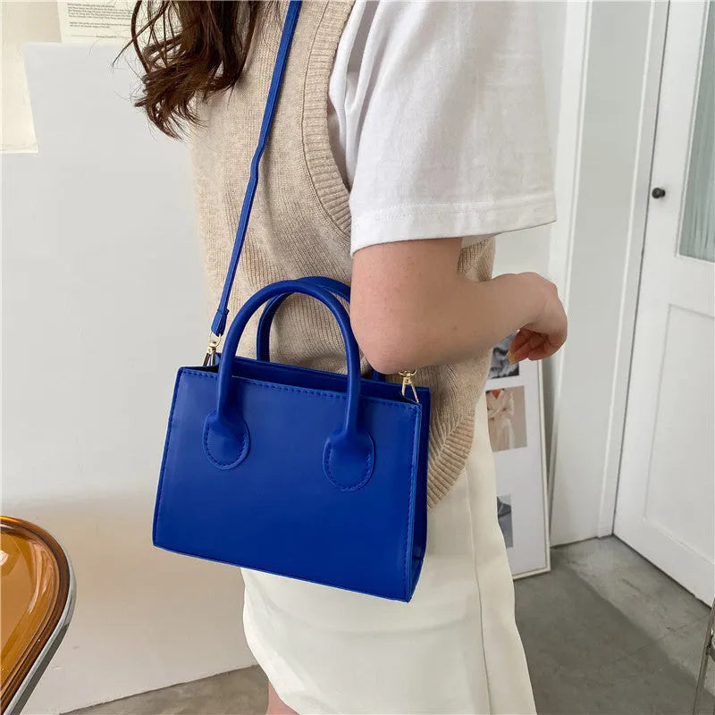 PU synthetic leather small horizontal square shoulder bag in five colour options showing document pocket and single strap